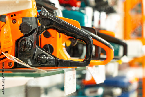 A Variety of Electric Chainsaws Displayed on Shelves in a Tool Store, Showcasing Their Unique Designs and Features for Wood Cutting Enthusiasts and Professionals
