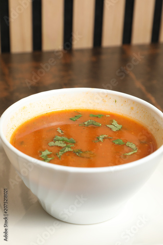 Soupe marocaine servie dans un bol blanc sur une table en bois