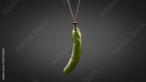 siderite. A slender green jade pendant shaped like a silique on a dark background. event programs, museum guides, designed for cultural heritage projects and event programs, used by fitness trainers.