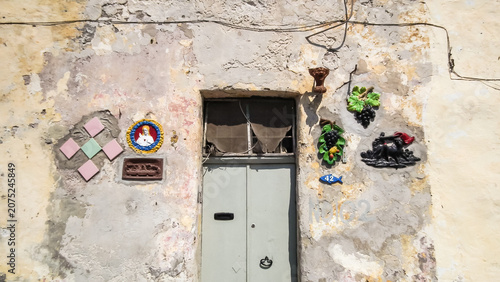 Various stucco icons and decorations on the wall of the house in Marsaxlokk city in Malta
