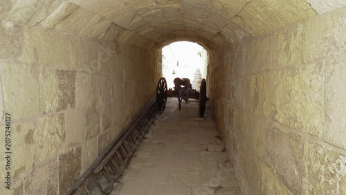 Foto Old cannon stands in tunnel embrasure of St John Bastion fortress courtyard in Vittoriosa Birgu city in Malta