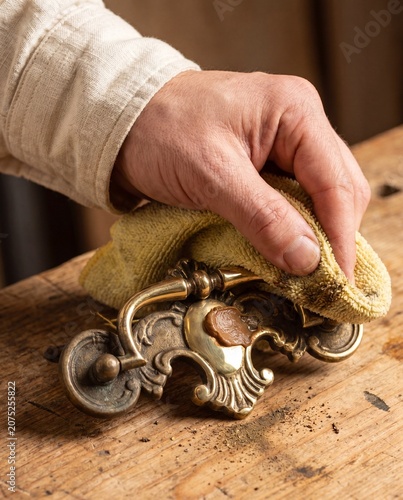 Hand polishing vintage brass drawer pull half cleaned macro antique hardware restoration