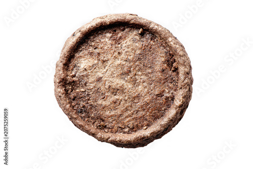 Ancient circular clay coin mold with rough textured surface for metal casting isolated on a transparent background