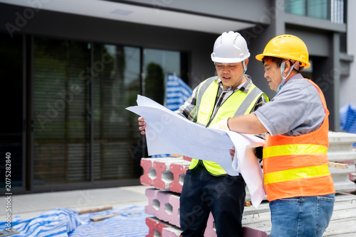 Foto Two civil engineers verifying details on an architectural blueprint