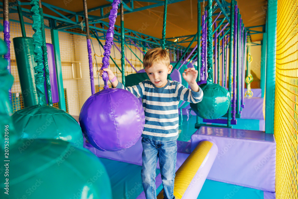 Obraz premium Boy balancing on obstacle course in indoor playground