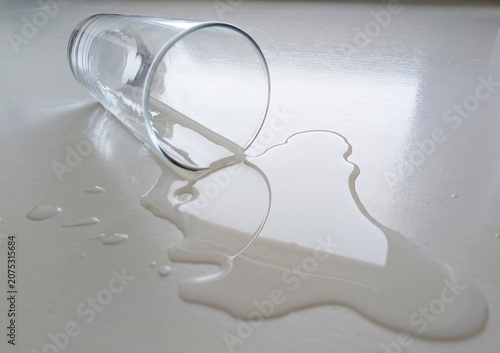 Cuadro en lienzo Umgekipptes Glas mit verschüttetem Wasser auf hellem Tisch