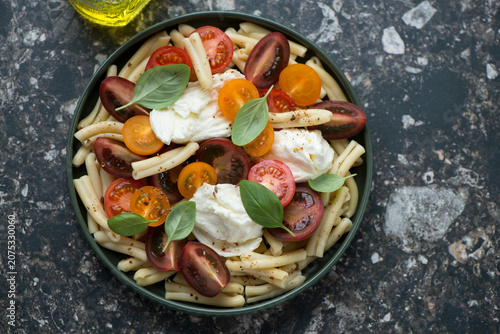 Foto Casarecce pasta salad with mixed tomatoes and torn mozzarella, horizontal shot o