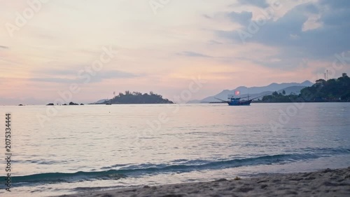 Calm tropical bay with fishing boat at sunset