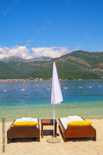 Obraz na plátně Beach vacations, chaise lounges and beach umbrella