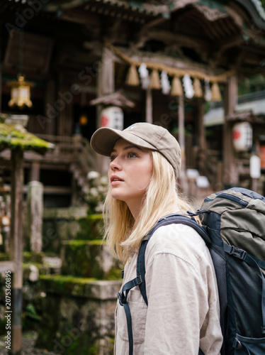 日本の伝統的な神社を訪れる外国人女性バックパッカー