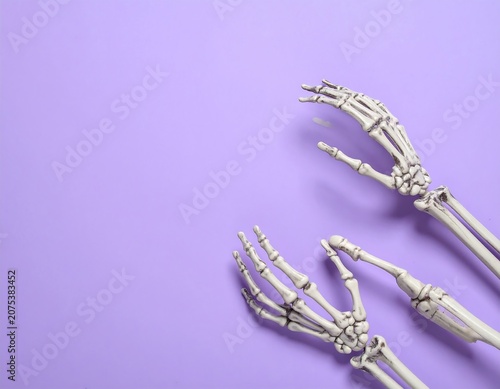 A close-up of two skeletal hands on a purple background