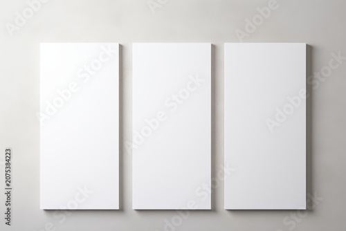 Three blank vertical poster frames on a wall, minimalist mockup, no text