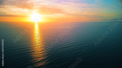 A breathtaking panoramic view of a dramatic golden sunset over the Mediterranean Sea in Agropoli, Cilento coast. The sky is filled with vibrant hues of orange, pink, yellow, and blue clouds, while the