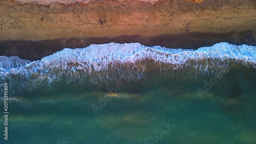 Aerial photography in 4K format – aerial view (ultra-high resolution) of sunset or sunrise on the seashore. Reflection in the water. Beautiful summer seascape of the Mediterranean Sea. Background 