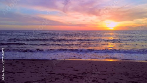 A breathtaking panoramic view of a dramatic golden sunset over the Mediterranean Sea in Agropoli, Cilento coast. The sky is filled with vibrant hues of orange, pink, yellow, and blue clouds, while the