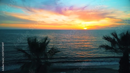 A breathtaking panoramic view of a dramatic golden sunset over the Mediterranean Sea in Agropoli, Cilento coast. The sky is filled with vibrant hues of orange, pink, yellow, and blue clouds, while the