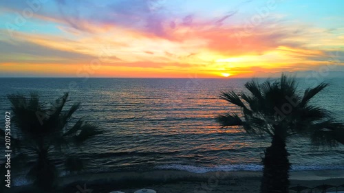 A breathtaking panoramic view of a dramatic golden sunset over the Mediterranean Sea in Agropoli, Cilento coast. The sky is filled with vibrant hues of orange, pink, yellow, and blue clouds, while the