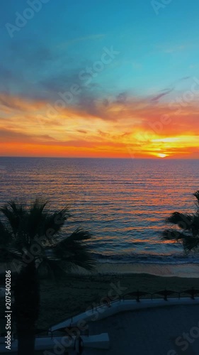 A breathtaking panoramic view of a dramatic golden sunset over the Mediterranean Sea in Agropoli, Cilento coast. The sky is filled with vibrant hues of orange, pink, yellow, and blue clouds, while the
