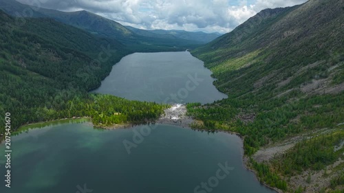 Epic aerial drone panorama showing the connection of Lower and Middle Multinskoe lakes with a white water river stream flowing through the moraine dam in Altai.