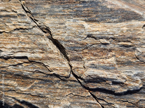 фотографія Close-up view of layered rock texture with natural striations and a prominent cr