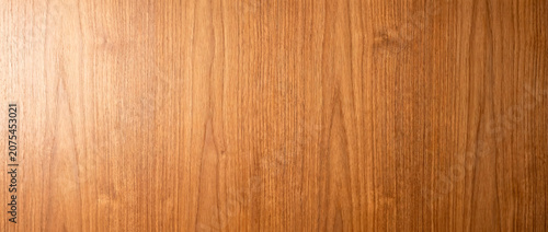 Warm teak wood veneer texture background with natural straight grain pattern
