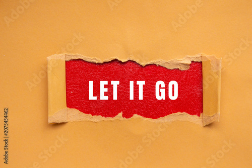 Fotografía Torn brown paper revealing the concept let it go in white text on a vibrant red