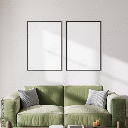 Two blank poster frames mockup on neutral living room wall above green sofa, sunlight, 3d render