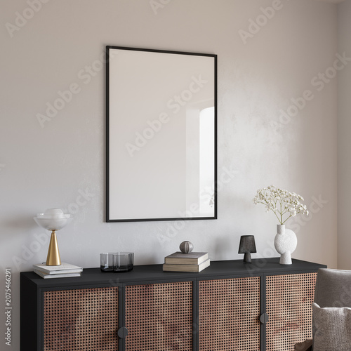 Blank poster frame mockup above rattan sideboard in beige interior with lounge chair, 3d render