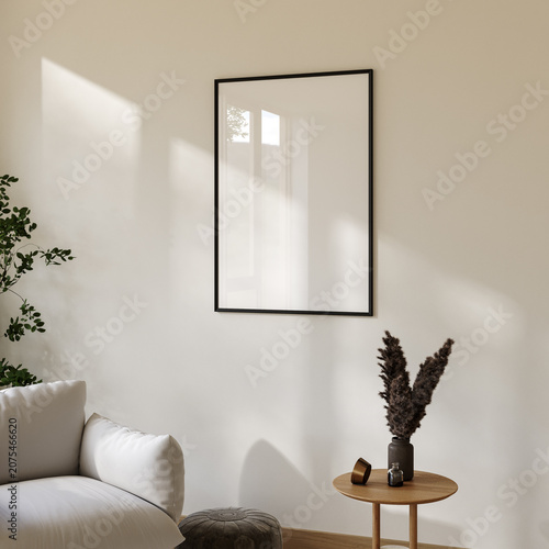 Blank poster frame mockup on beige living room wall with white lounge chair and sunlight, 3d render