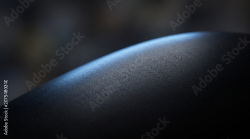 Abstract dark smooth matte surface with subtle blue edge light macro background