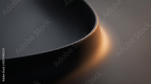 Abstract dark smooth matte surface with warm golden amber edge light macro background