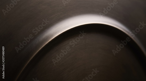 Abstract dark brushed metal background with a smooth sweeping circular curve