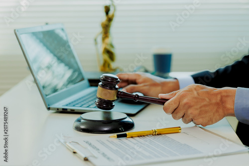 Foto Attentive law firm partner cross-checking witness statements with statutory codes on laptop monitor