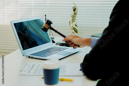 Photos Precise paralegal auditing lawsuit parameters on laptop to prepare flawless courtroom defense strategy