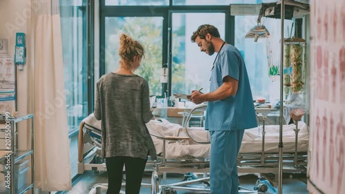 Medical professionals collaborating in a hospital room with a patient on a bed