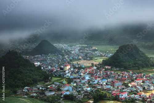 Elevated view of a rural Quan Ba town surrounded by limestone hills and low clouds along the Ha Giang Loop in northern Vietnam