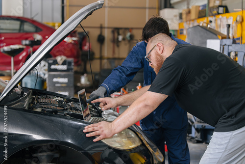 Car engineer technician worker, Technician team use laptop computer for tuning ECU with software.
