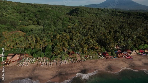 Aerial View of Virgin Beach with Palm Forest, Traditional Boats, Ocean Waves and Mount Agung in Bali