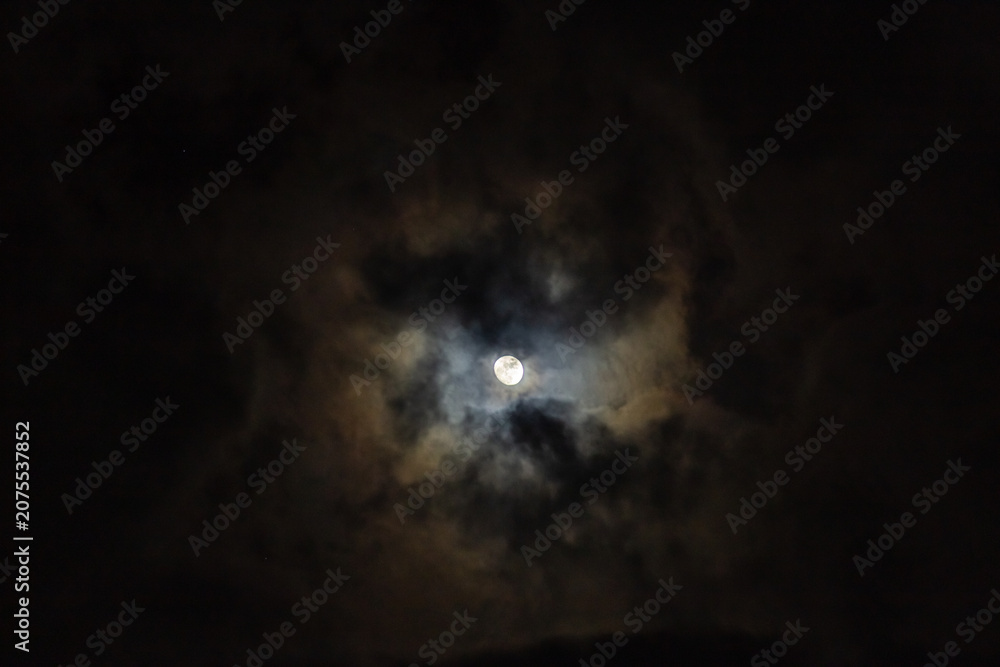 Fototapeta premium Full moon and clouds in the night sky. Night sky background.