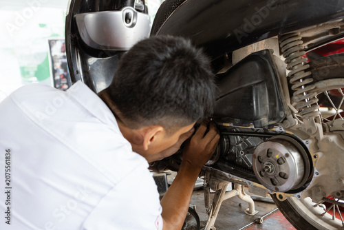 Motorcycle Mechanic Performing Rear Wheel Maintenance in Service Workshop