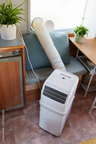 Portable air conditioner unit operating inside a modern camper van during a summer heatwave
