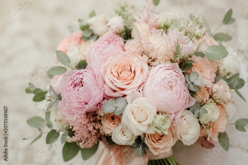 Elegant wedding bouquet with roses and peonies in soft romantic style.