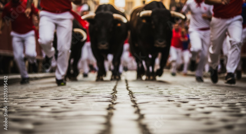 Running of the Bulls during the San Fermin Festival on a Cobblestone Street in Spain