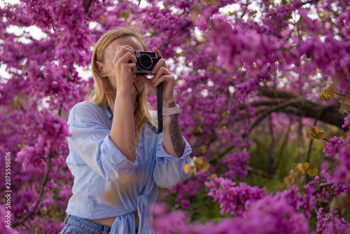Fotografie Woman capturing spring blossoms on camera, enjoying outdoor photography hobby in