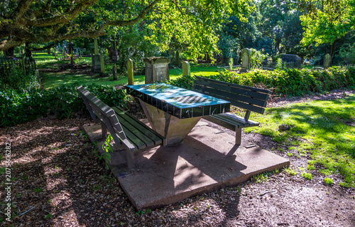 Chess table with benches in shady historic cemetery garden, Auckland, New Zealand, 1 January 2024