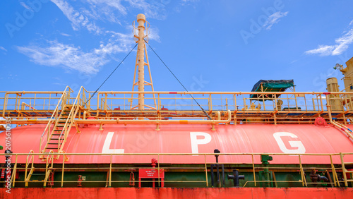 Large LPG storage tank on a cargo ship vessel under blue sky. Liquefied petroleum gas transportation and maritime energy logistics industry