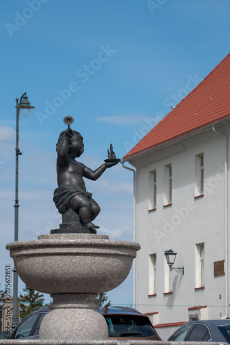 Child statue on stone fountain in town square