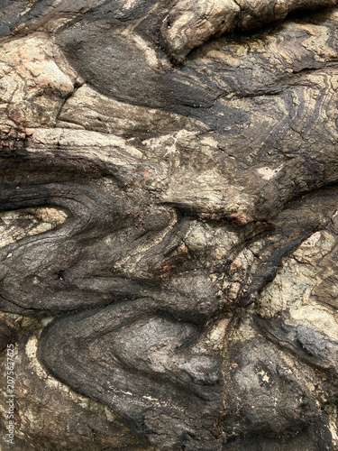 Fotografi Close-up of weathered rock showing layered striations, swirls and mineral veins