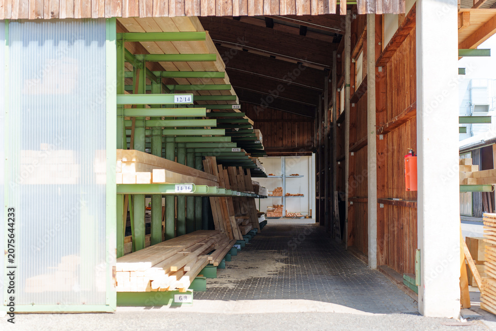Obraz premium Timber Planks Stored on Green Metal Racking System