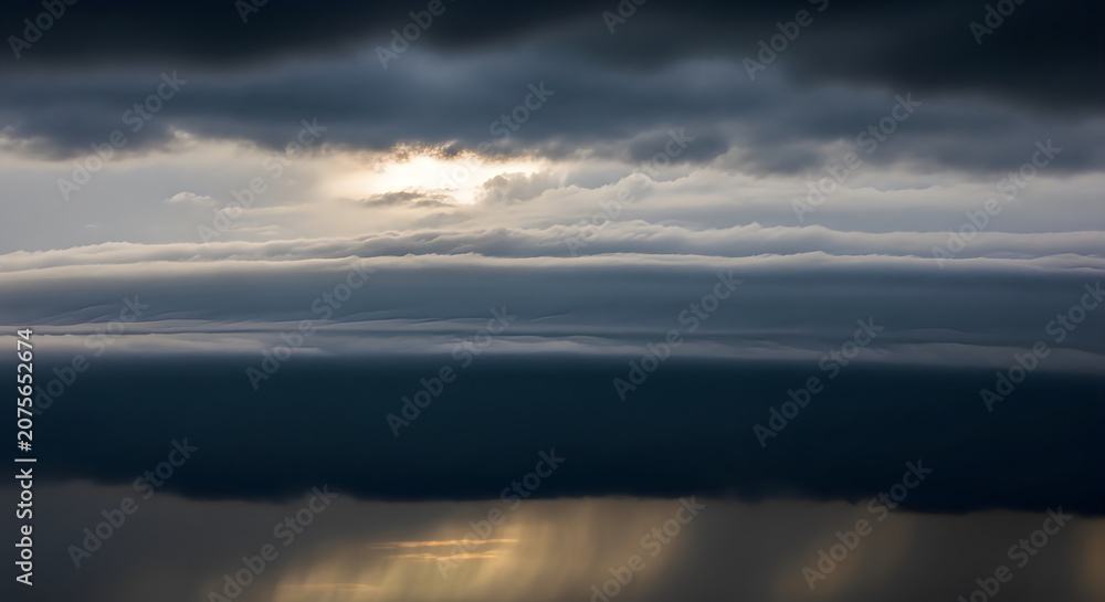 Fototapeta premium Dramatic Sunrise Over Calm Ocean with Cloudy Sky and Golden Light Reflection